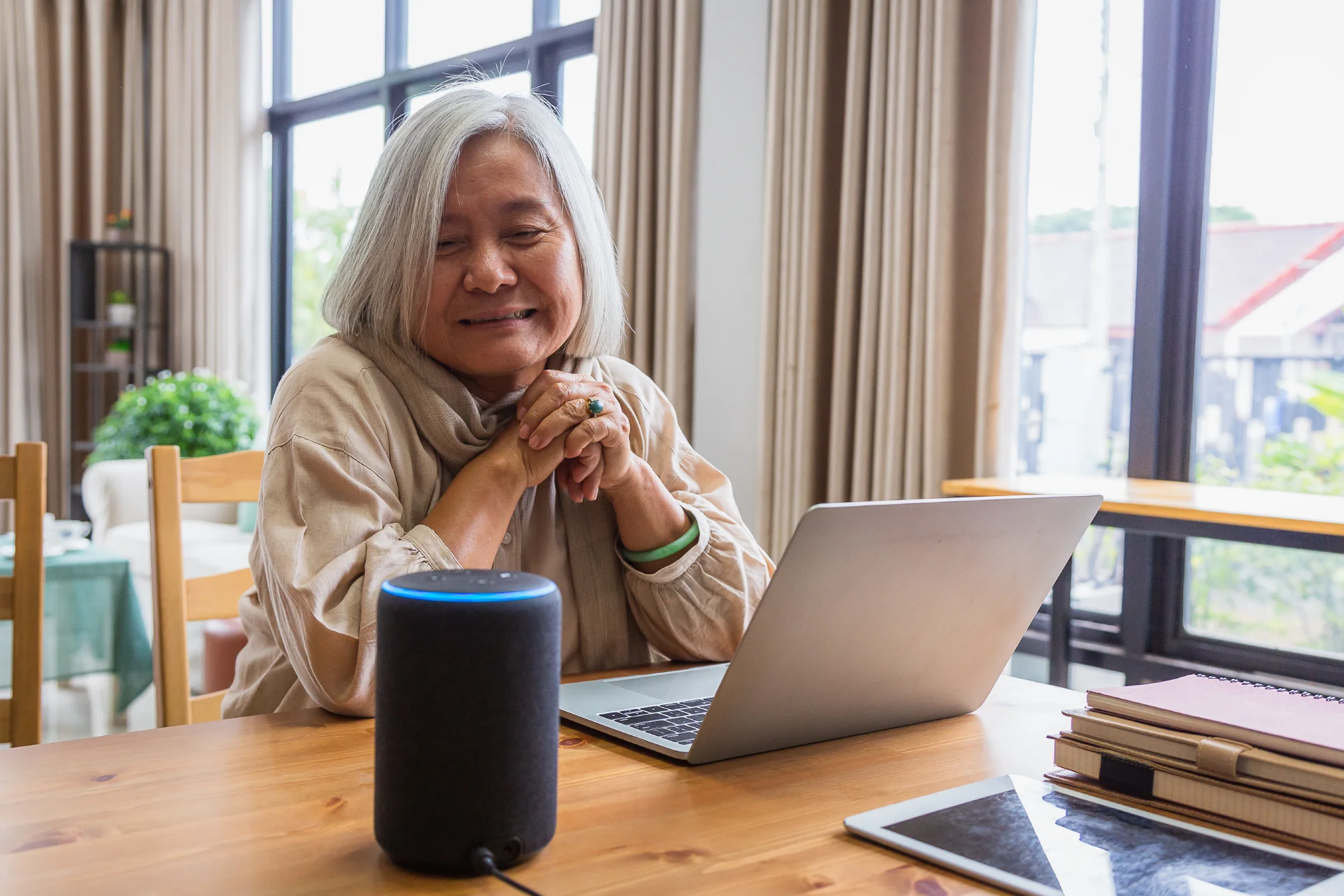 senior resident using bluetooth speaker and laptop